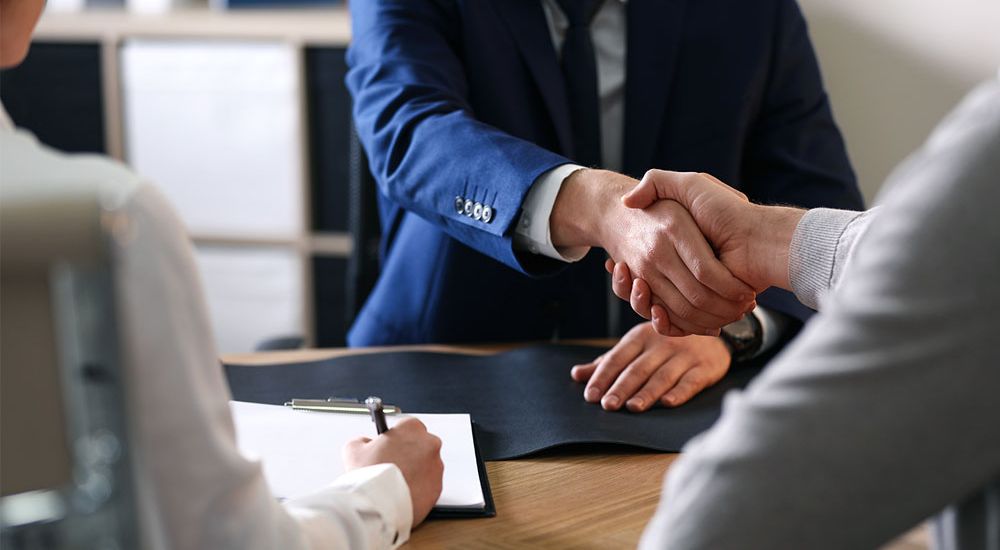 Lawyer shaking hands with his client after providing tax attorney services