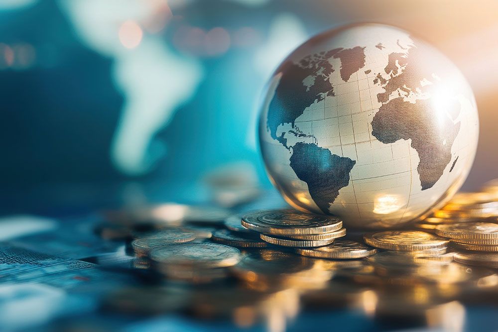 Globe resting on stacked coins, symbolizing global finance and economies in motion