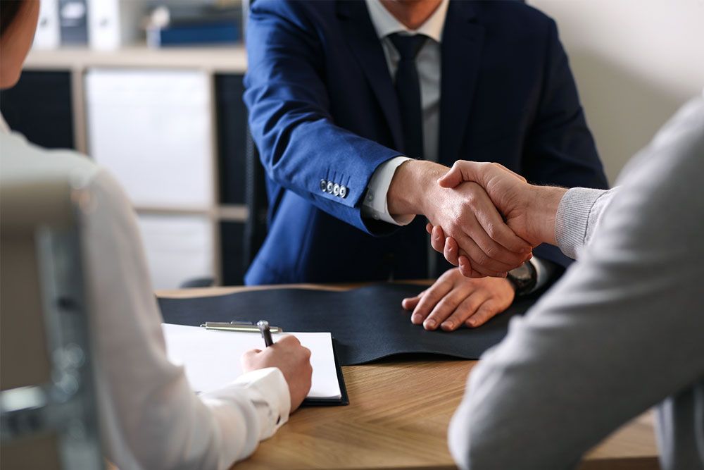 Lawyer shaking hands with his client after providing tax attorney services